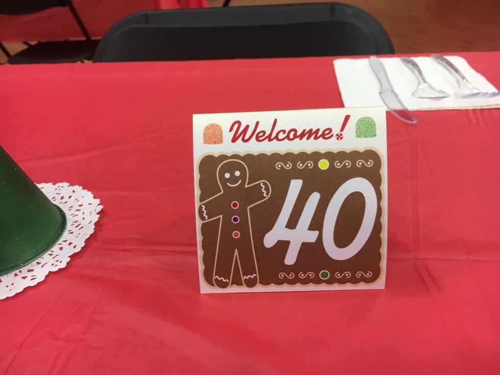A tent card that says welcome and has a image of a cookie with a table number on it